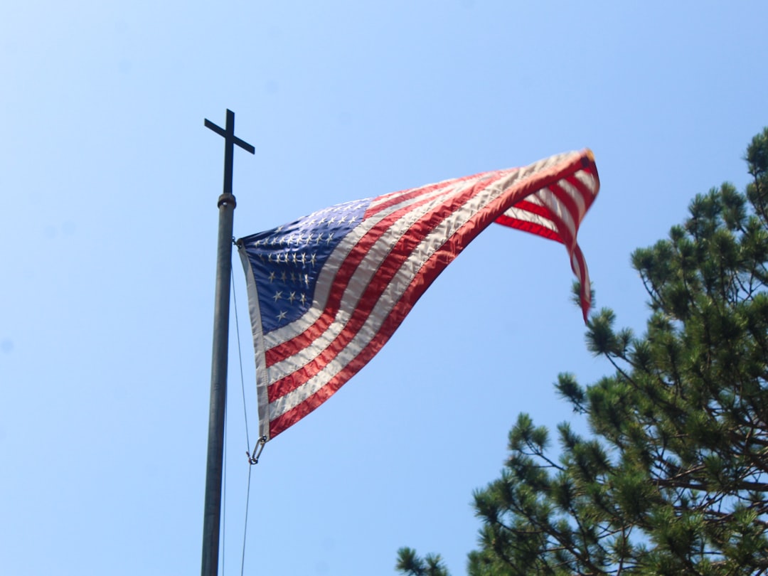 An american flag flying in the wind on a pole