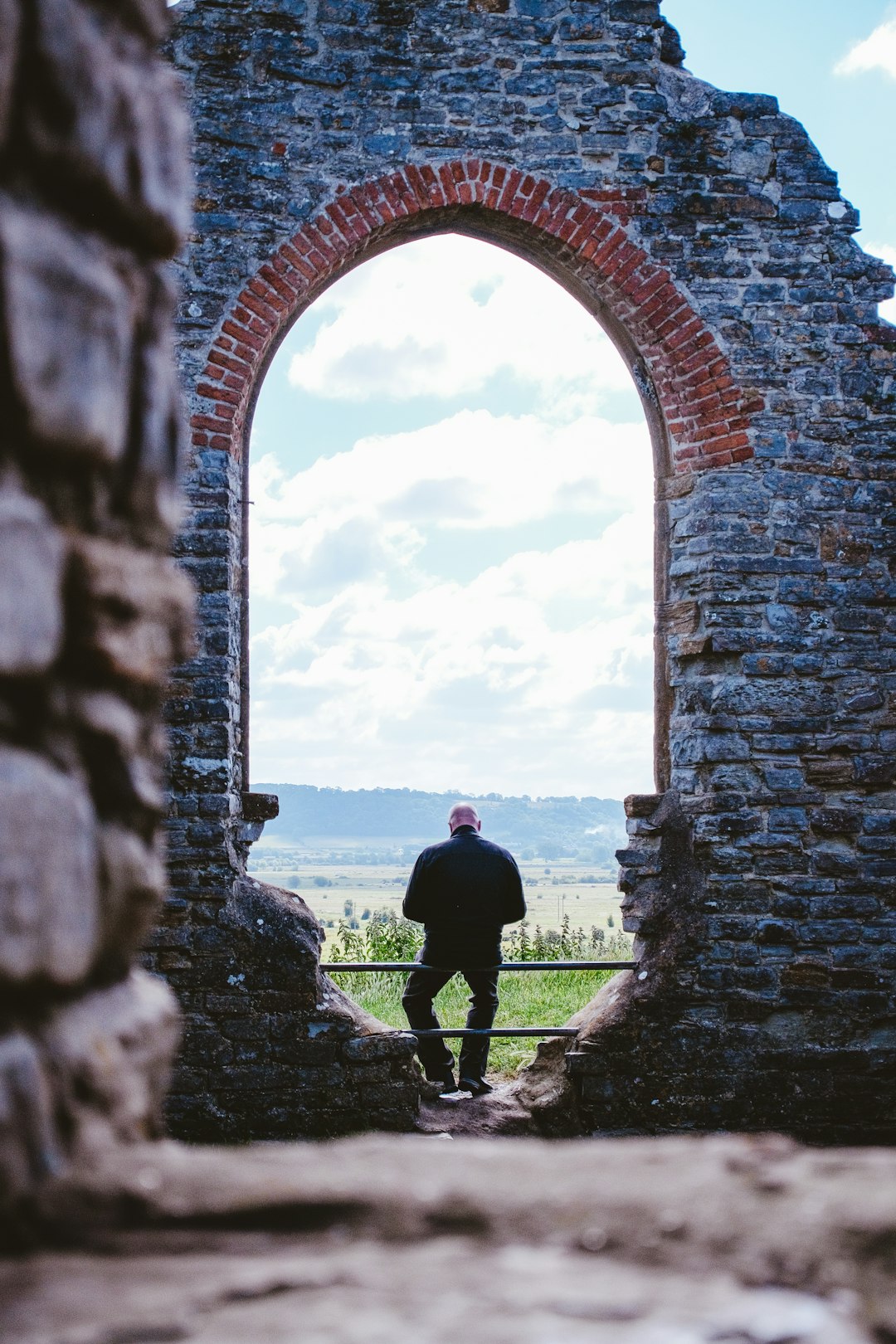 a man standing in a doorway of an old brick building
